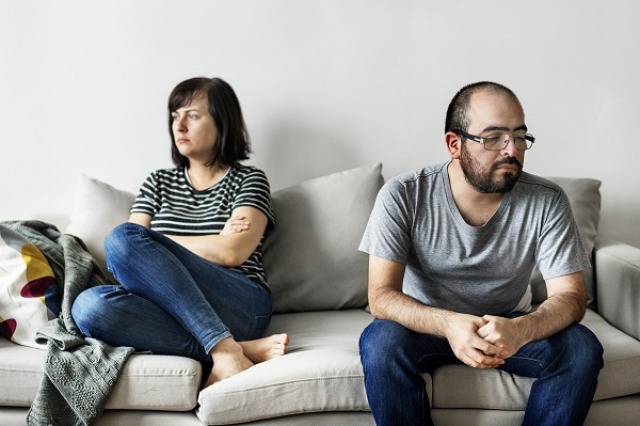 Unhappy couple arguing on the sofa